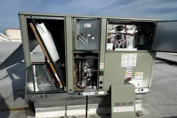 Professional commercial HVAC technician servicing rooftop unit