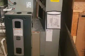 Professional furnace maintenance technician performing annual service